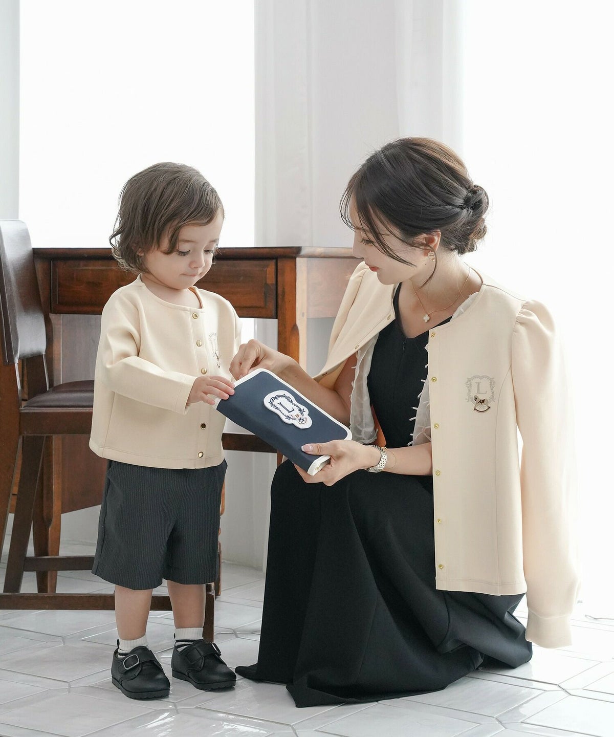 カーディガンレディースダンボールニットトップスクルーネックゴールドボタン木馬刺繍エンブレム刺繍フレアラインパネルライン袖口カフスパフスリーブスラッシュポケット羽織りトップス肩掛けリンク親子コーデ